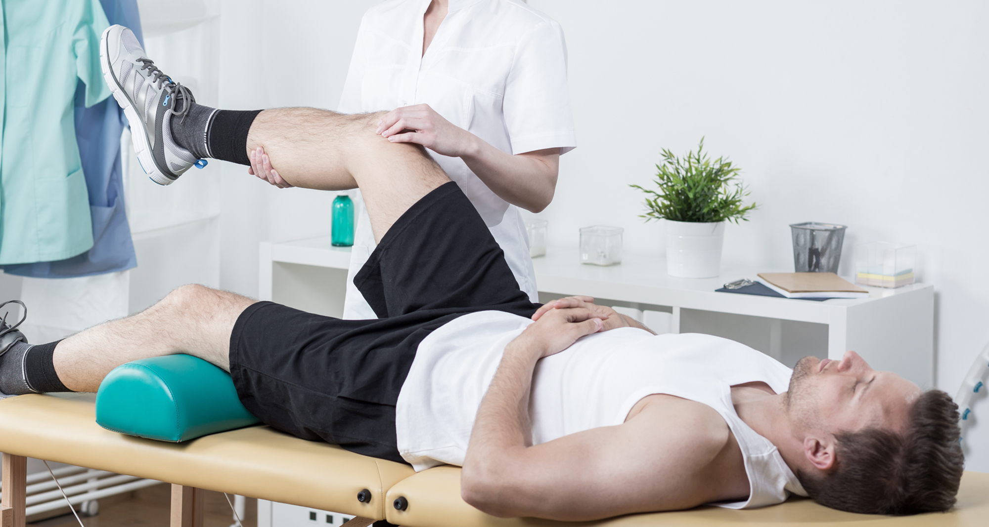 Don’t worry, the pain will be gone in a moment Shot of a young smiling physical therapist and his patient